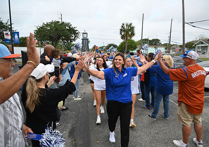 银河网上赌场官网 Whitecaps Athletic Director and Head Softball Coach, Kelly Raines, leads the Whitecaps softball players through a crowd of high-fives from students, faculty and staff that gathered to give the team a send-off on 2025年5月2日, at the college’s main campus.